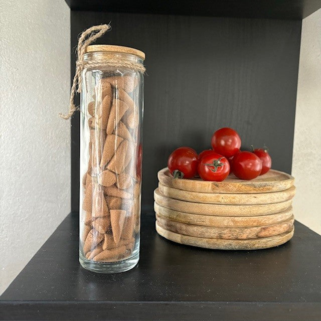 Wierookpuntjes in glazen pot met brander in dop.